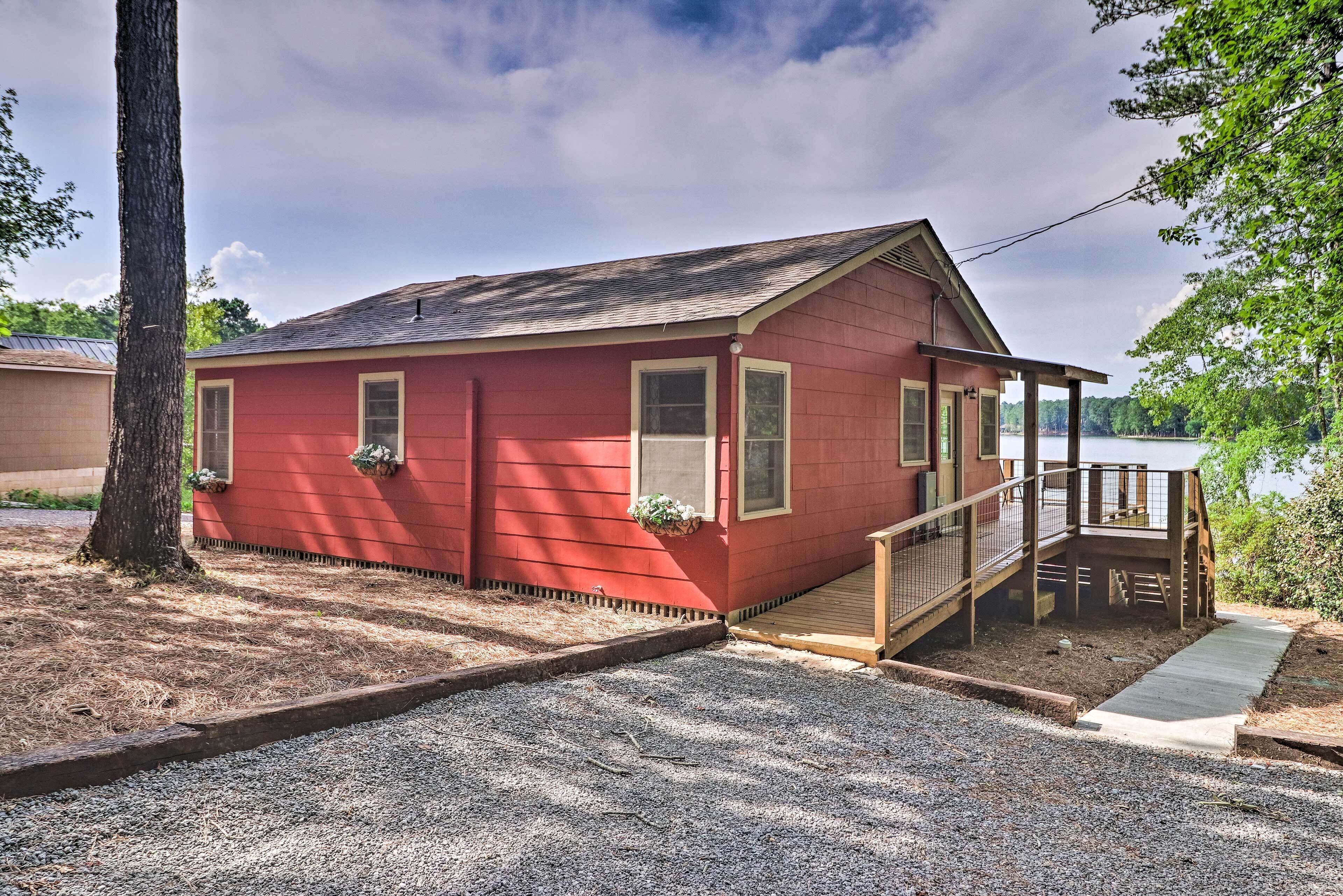 A red single-story house with a porch and a small deck.