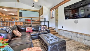 A spacious living room with a sectional sofa, ottoman, and a large mirror. - Spacious Glen Rose Home on Paluxy Riverfront (Glen Rose)