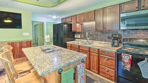 A kitchen with wooden cabinets, a granite countertop, a refrigerator, a stove, and a coffee maker. - Tamaqua Apartment w/ Fire Pit & Gas Grill! (Tamaqua)