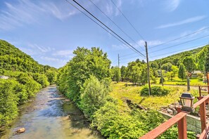 A river flowing through a lush green landscape with a wooden bridge and houses in the background. - Tamaqua Apartment w/ Fire Pit & Gas Grill! (Tamaqua)