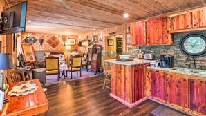 Une cuisine rustique avec des meubles en bois, un îlot central et un pare-feu en pierre.