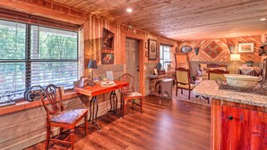 Un intérieur rustique en bois comprenant un coin repas, une cuisine et un espace salon.