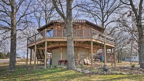 A wooden cabin with a balcony, surrounded by trees. - 'sunset Bluff Treehouse': On Bull Shoals Lake! (Lead Hill)