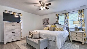 A bedroom with a bed, a TV, a ceiling fan, a dresser, and a nightstand. - Welcoming Hattiesburg Home < 2 Mi to Usm! (Hattiesburg)