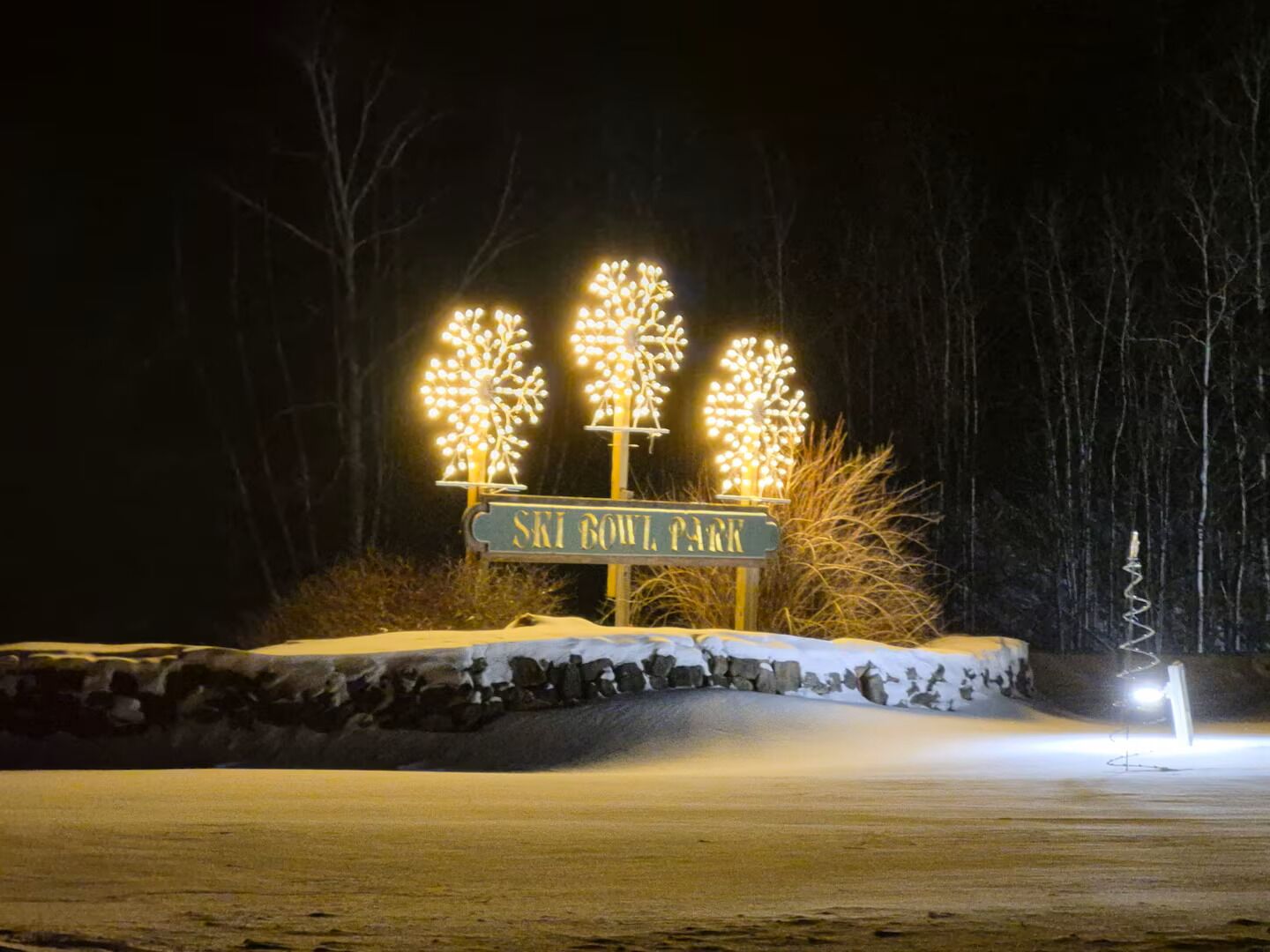 Un panneau indiquant le « Ski Bowl Park », agrémenté de décorations lumineuses en forme d’arbres.