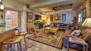 A cozy living room with a fireplace, leather sofa, wooden coffee table, and rustic decor. - Tenn River Cabin w/ Hot Tub - 10 Mi to Chattanooga (Chattanooga)