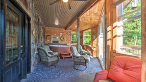 A wooden cabin interior with a bar area, wicker furniture, and large windows. - Tenn River Cabin w/ Hot Tub - 10 Mi to Chattanooga (Chattanooga)