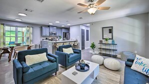 A modern living room with two sofas, a coffee table, and a dining area with chairs.