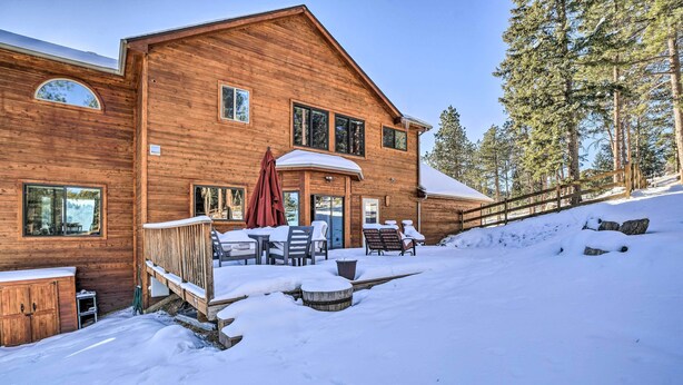 A wooden lodge with a covered patio and outdoor seating.