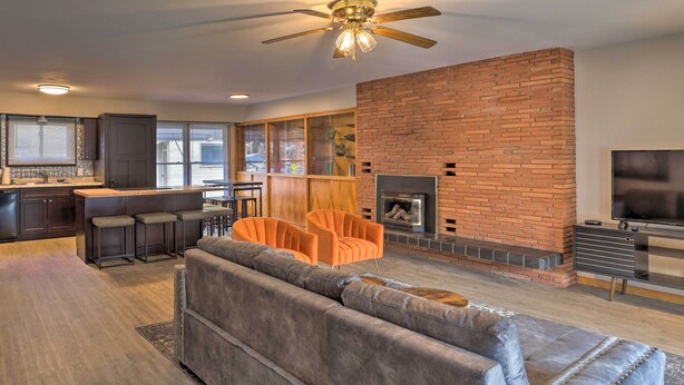 A modern living room with a brick fireplace, a sofa, and a TV.