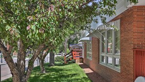 A brick building with large windows and a covered porch.