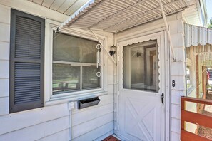 Fachada blanca con ventana, puerta y buzón.