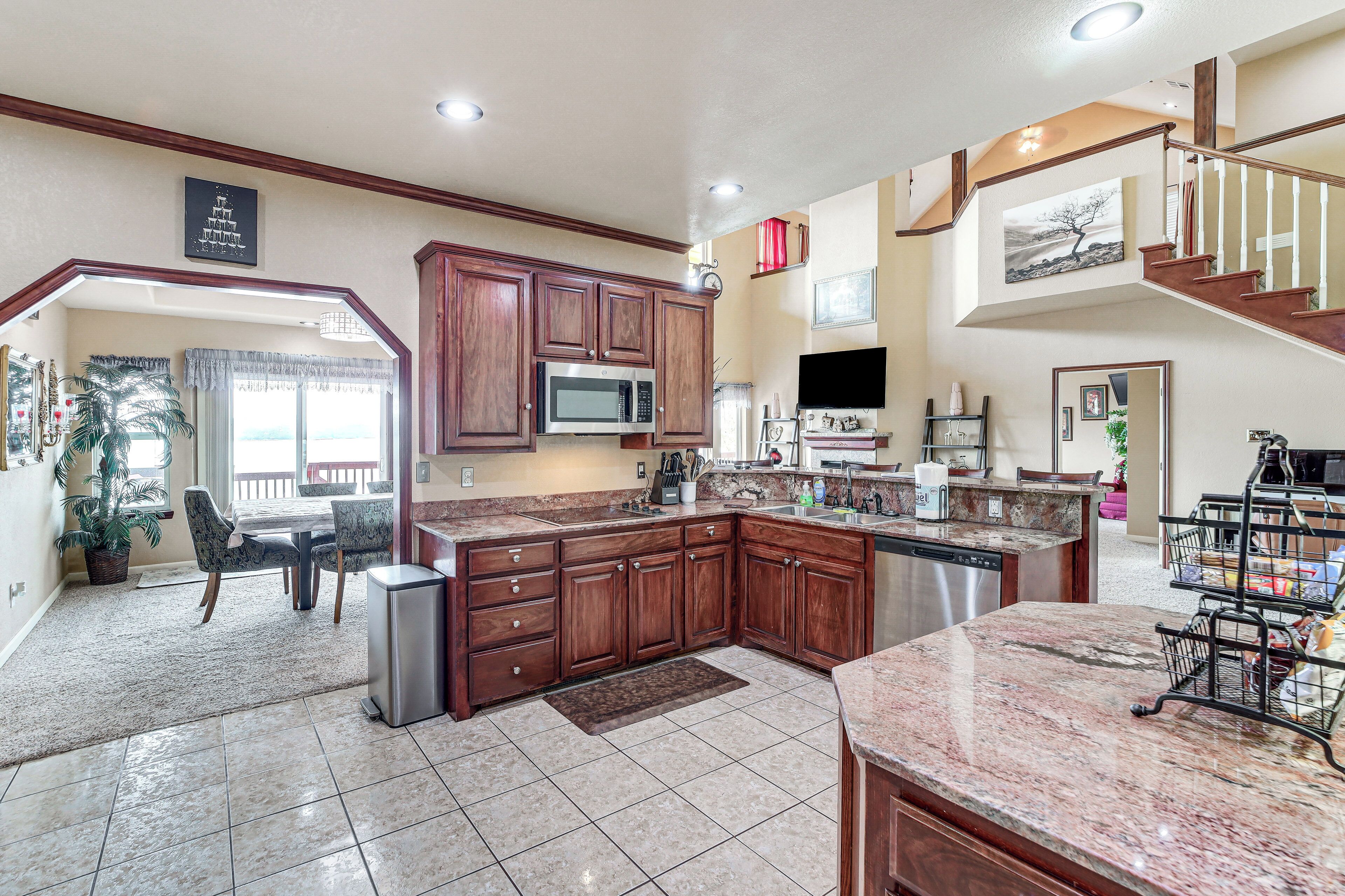A spacious kitchen with a large island, wooden cabinets, and a dining area with a table and chairs.