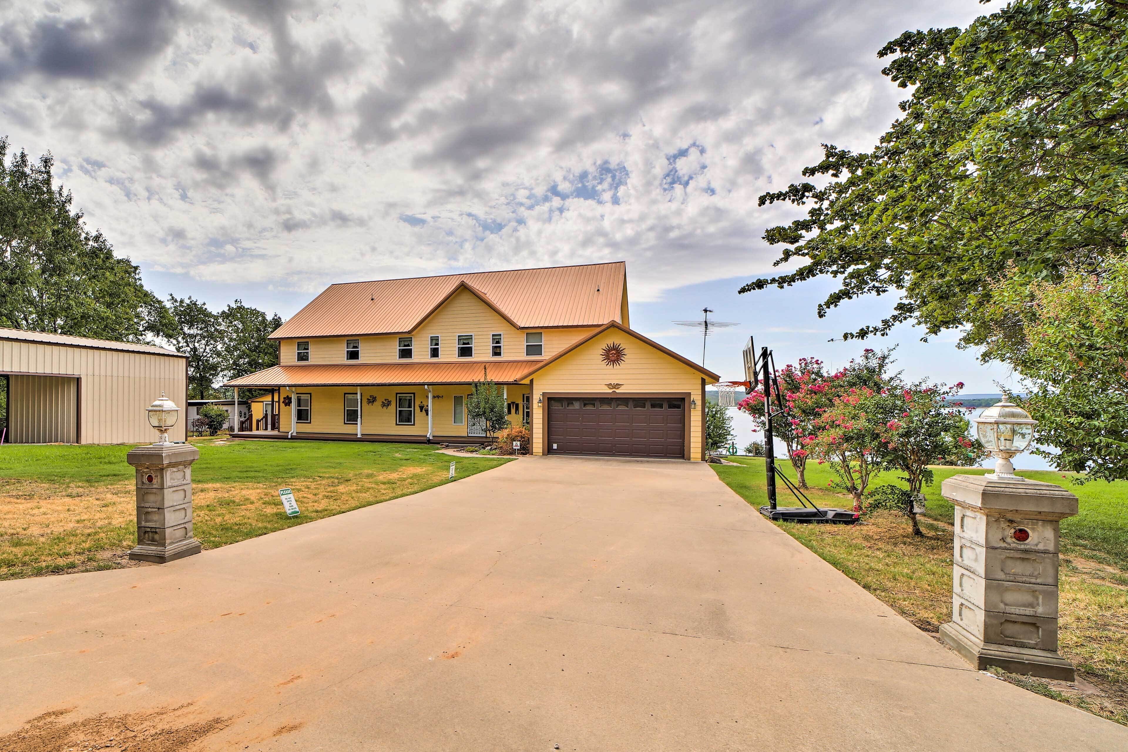 A two-story house with a garage, a driveway, and a lawn.