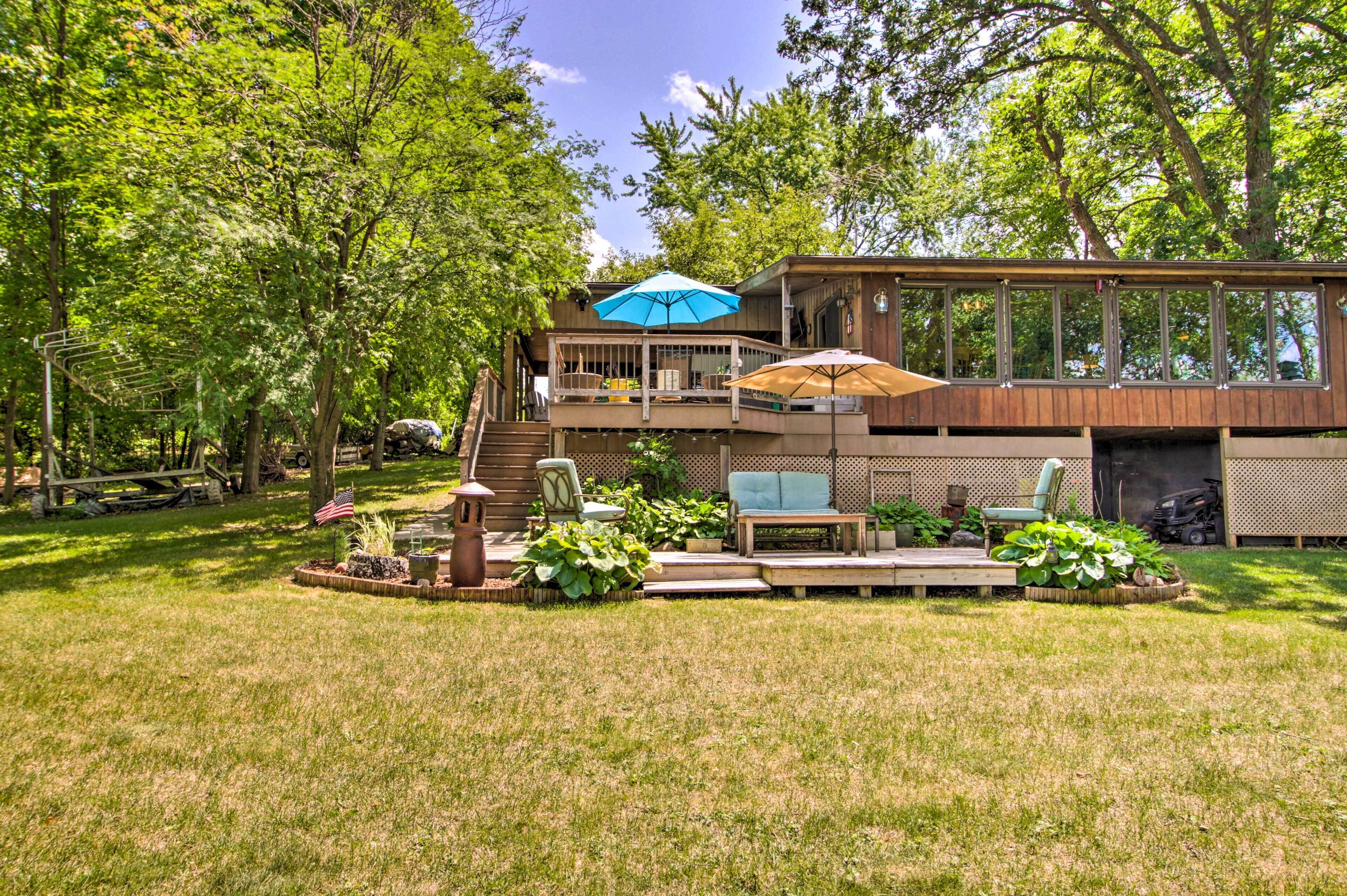 Une maison à deux étages dotée d’une terrasse, de mobilier d’extérieur et d’un espace patio.