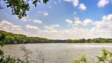 A lake with a forested shoreline and a clear sky.