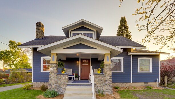 A two-story house with a stone chimney, a front porch with steps, and a front door. - Indiana Vacation Rental - Walk to Syracuse Lake! (Syracuse)