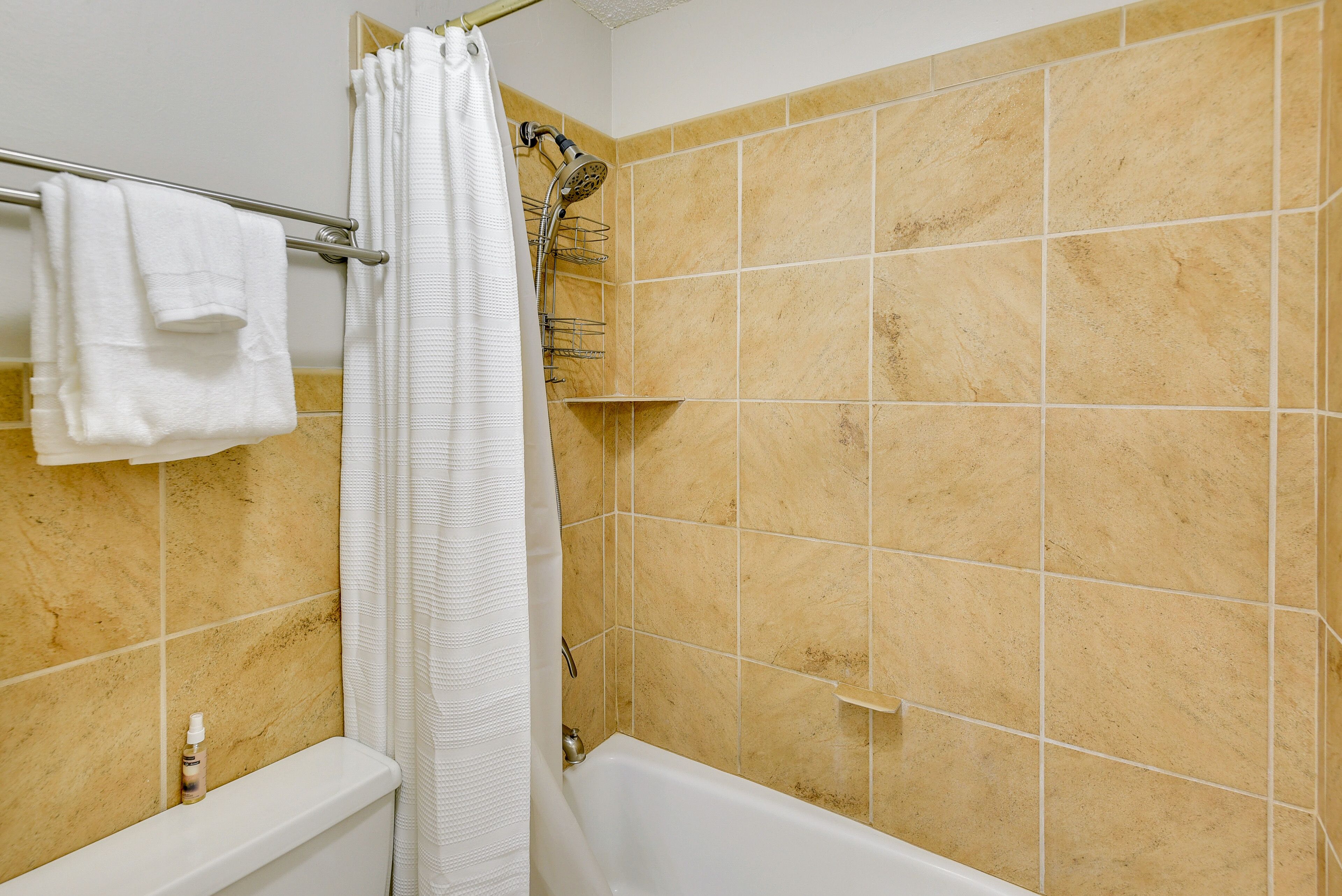 Ein Badezimmer mit Badewanne, Dusche und Handtuchhalter.