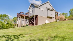 Ein zweigeschossiges Haus mit einer Holzterrasse und einer großen Garage.