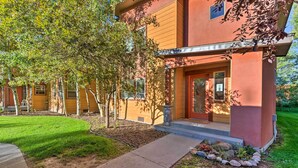 A modern two-story house with a red exterior, a front porch, and a well-maintained lawn. - Near Skiing & Hiking: Inviting Retreat in Victor! (Victor)
