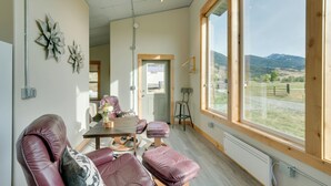 Ein modernes Interieur mit großem Fenster, einem Holztisch und Ledersitzmöbeln.