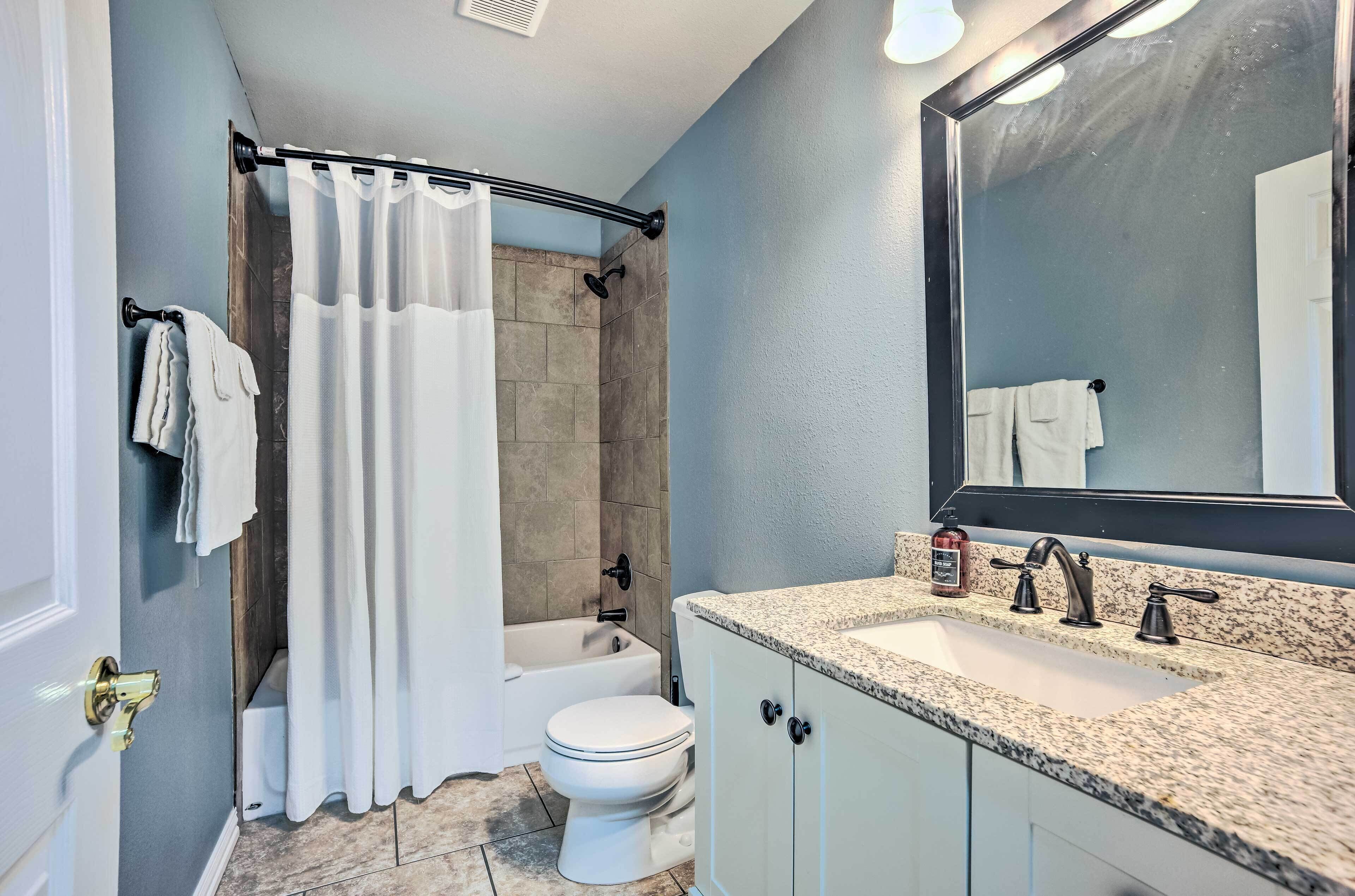 A bathroom with a shower, toilet, and sink.