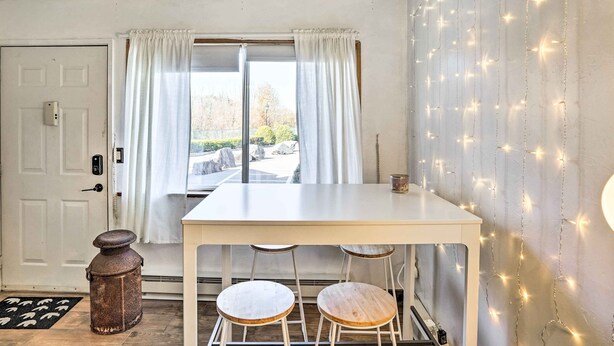 A room with a white table and two wooden stools, a white door, and a window with white curtains. - First-floor Hunter Condo < 1 Mi to Slopes! (Hunter)