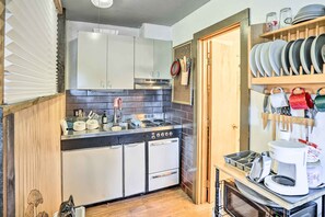 A compact kitchen with a built-in oven, a sink, and a stove. There are cabinets, a microwave, and a coffee maker on the counter. - First-floor Hunter Condo < 1 Mi to Slopes! (Hunter)