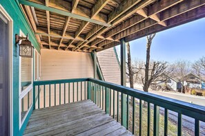A wooden deck with a green railing, a sloped ceiling, and a view of a street and houses. - Beech Mountain Retreat w/ Decks & Mountain Views! (Banner Elk)
