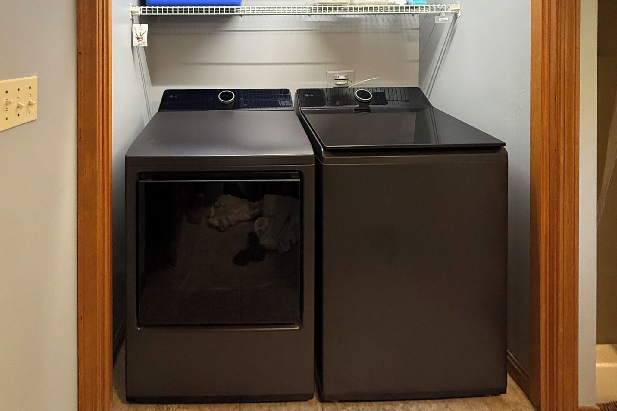 Un espace buanderie comprenant deux appareils superposés, dont l’un a une porte visible.