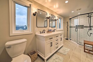 Features a double sink, glass-enclosed shower, and toilet.