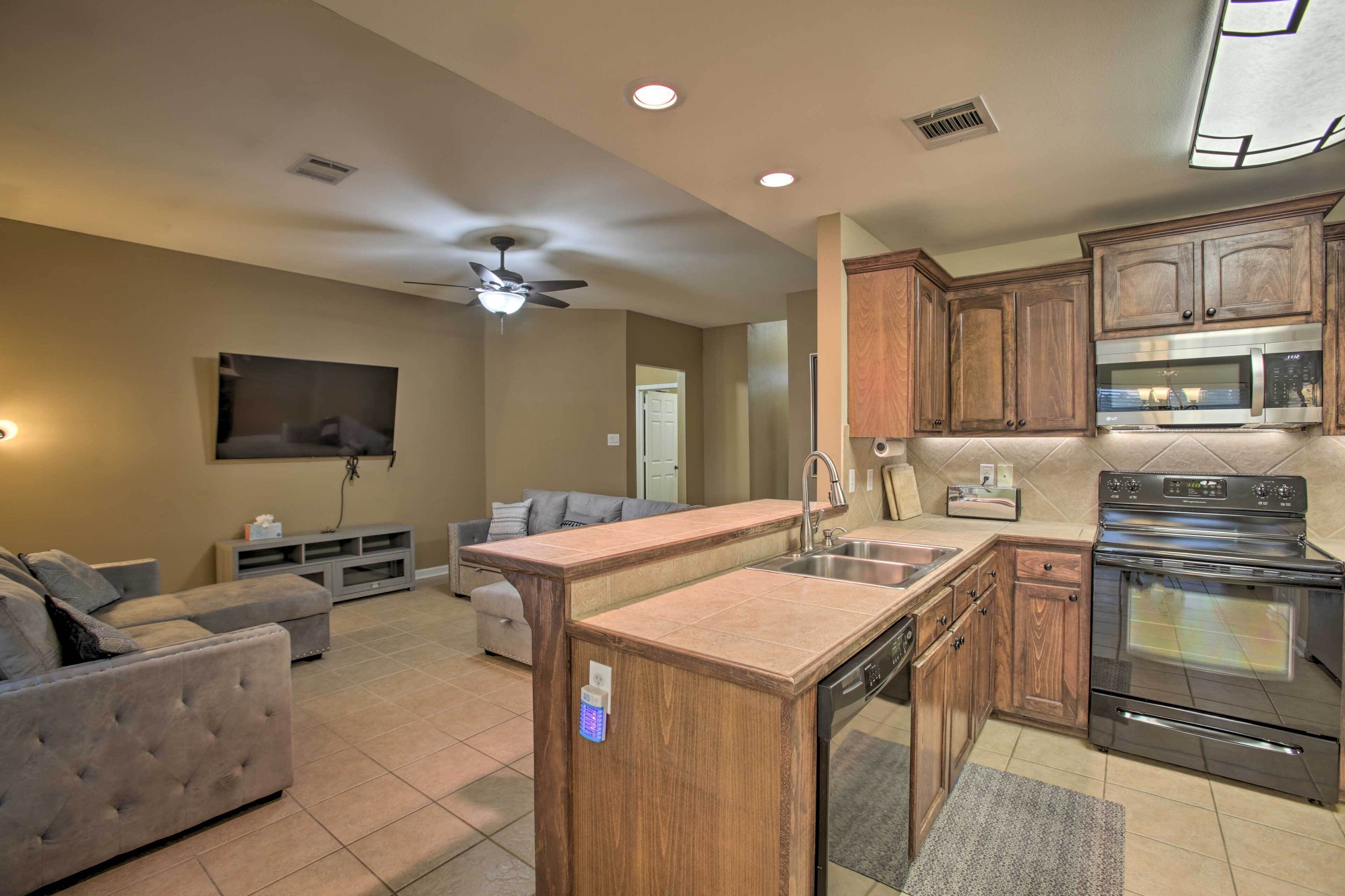 A modern kitchen with wooden cabinets, a stainless steel microwave, and a built-in oven.