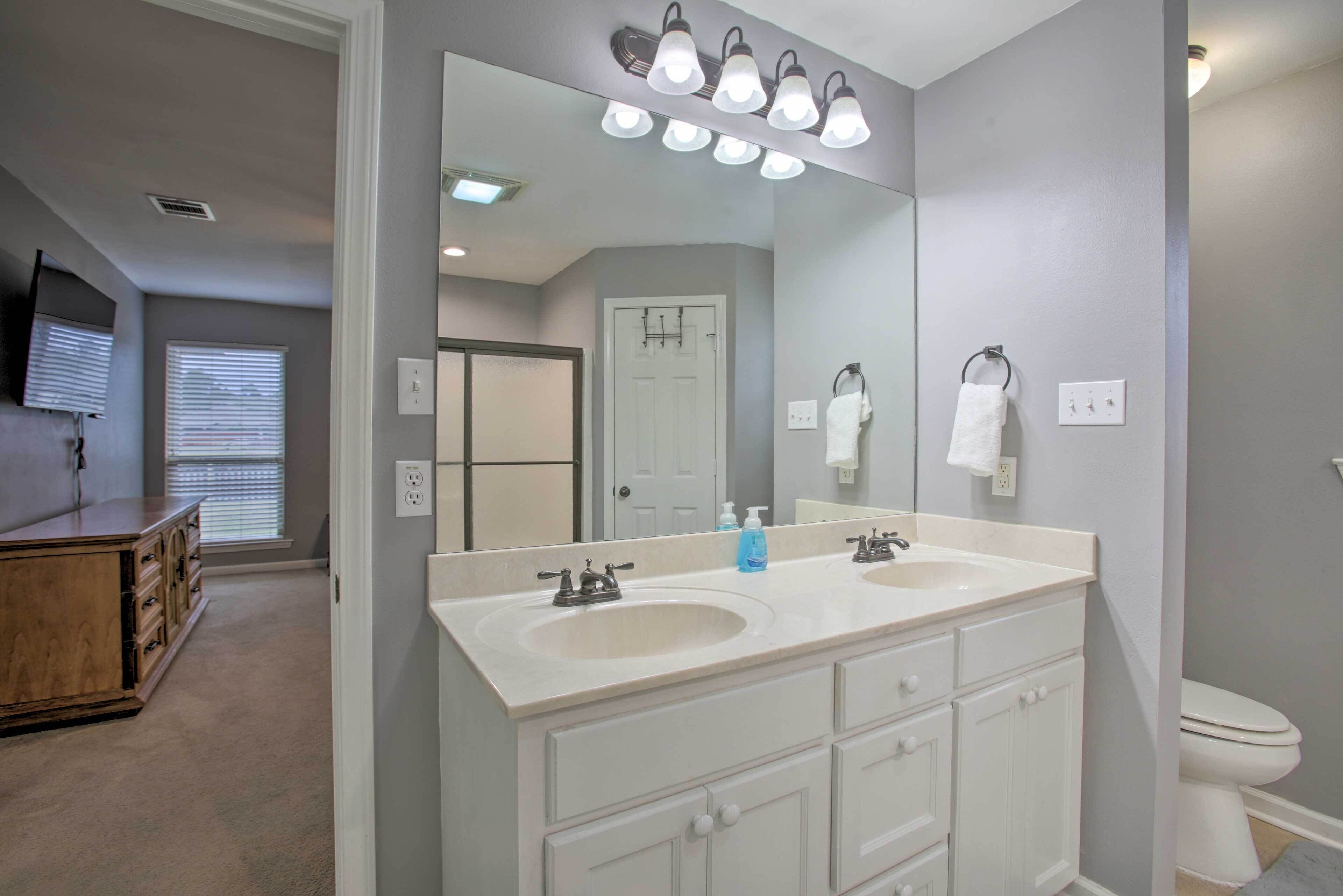 Une salle de bain avec deux lavabos, un grand miroir et des toilettes.