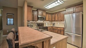 A modern kitchen with wooden cabinets, stainless steel appliances, and a central island.