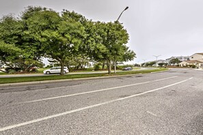 A residential street with a tree-lined sidewalk, a white car parked on the side, and houses in the background. - Brigantine Townhome Near Beaches & AC Casinos (Brigantine)