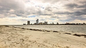 Ein Strand mit einer Stadtansicht im Hintergrund.