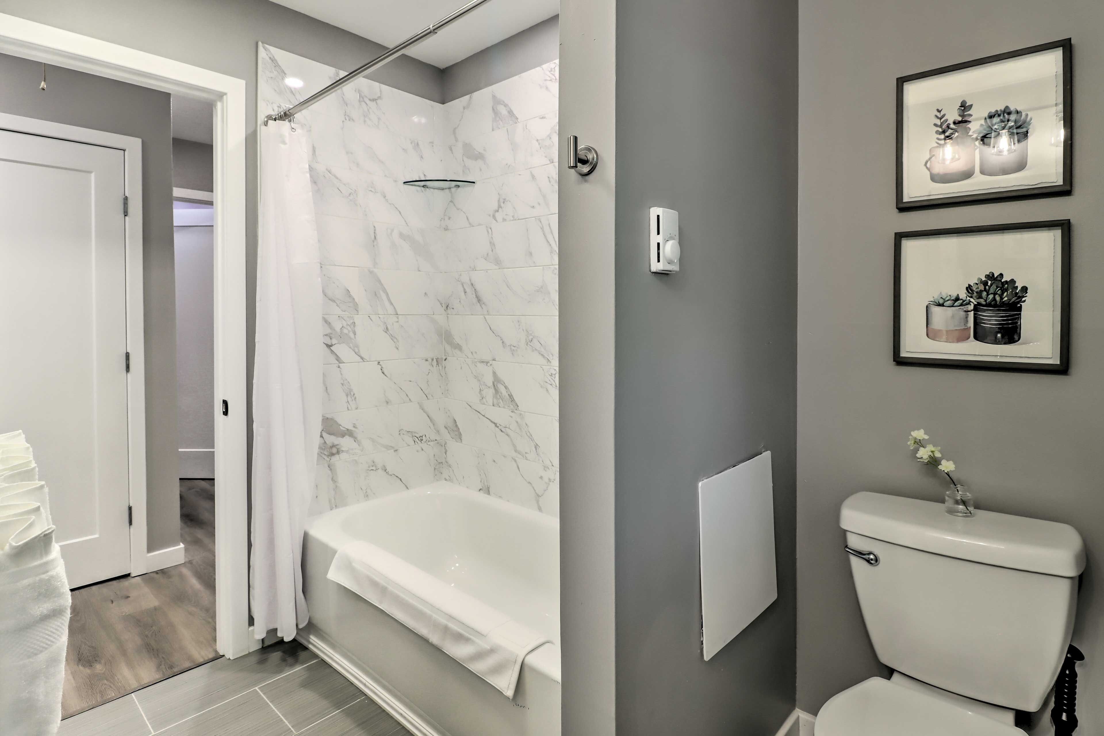 Un baño moderno con bañera, inodoro y cortina de ducha.