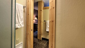 A wooden door leading to a bathroom with a towel rack and a visible shower area. - Condo at Northstar Village - Base of Ski Resort! (Truckee)