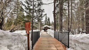 A snow-covered pathway leading to a cabin in a forest. - Condo at Northstar Village - Base of Ski Resort! (Truckee)