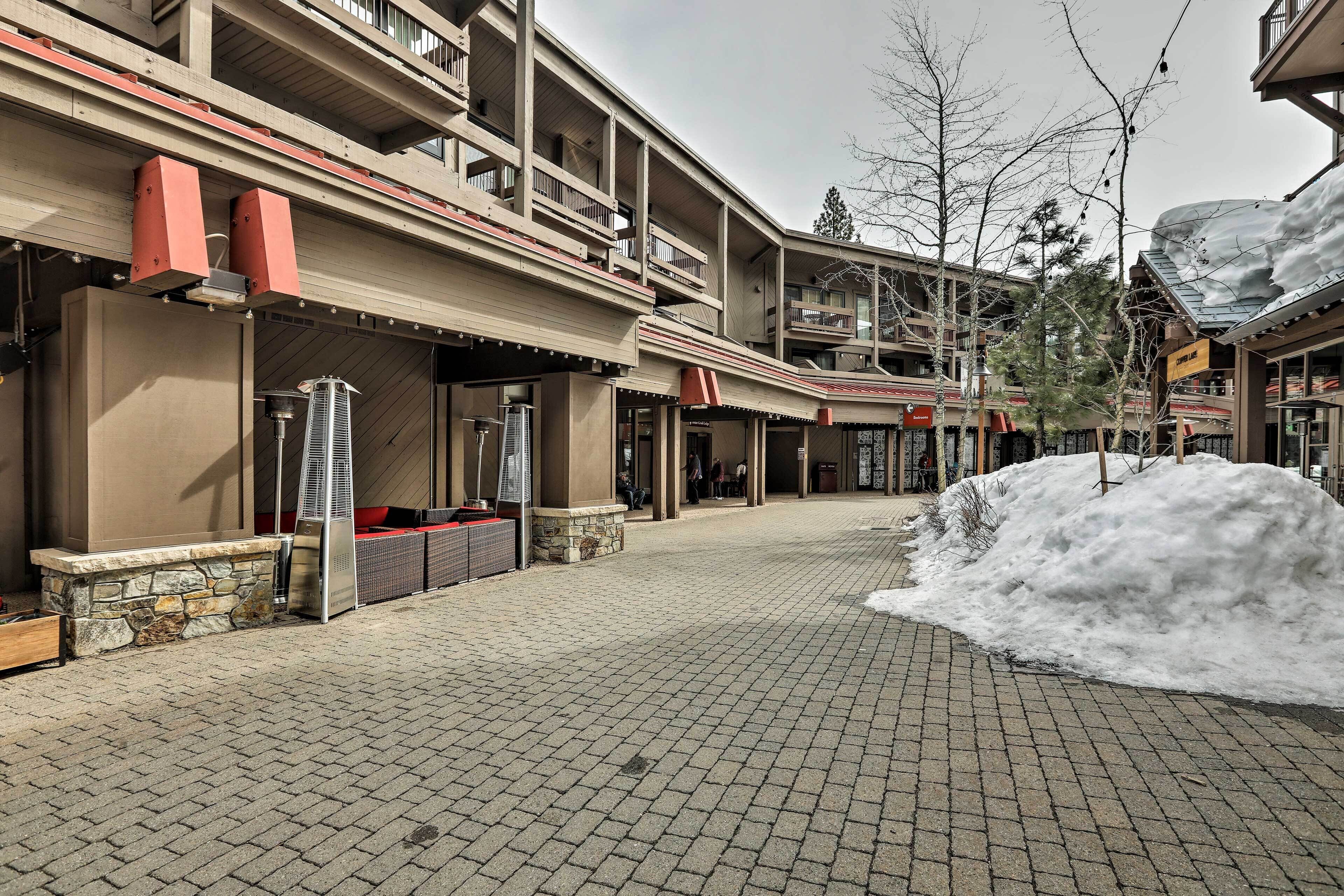 Un hôtel doté d’une cour pavée de briques, d’un espace extérieur aménagé pour s’asseoir et d’une zone enneigée.