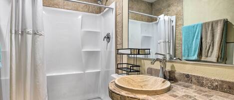 Un bagno con doccia, toilette, lavandino e specchio.