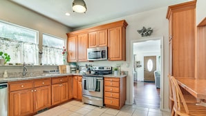 A kitchen with wooden cabinets, a stainless steel microwave, and a tiled floor. - Walk to Crown Zellerbach Trl: PNW 'celestial Inn' (Scappoose)