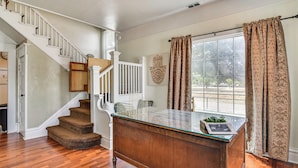 A spacious room with a wooden staircase, a glass-top desk, and a large window with curtains. - Walk to Crown Zellerbach Trl: PNW 'celestial Inn' (Scappoose)