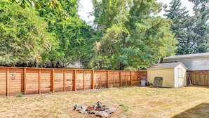 A backyard with a wooden fence, a shed, and a fire pit. - Walk to Crown Zellerbach Trl: PNW 'celestial Inn' (Scappoose)