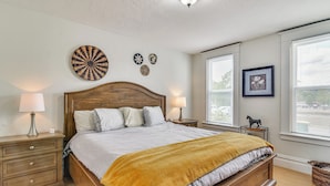 A bedroom with a wooden bed, two bedside tables, a nightstand, a wall-mounted lamp, and a window with blinds. - Walk to Crown Zellerbach Trl: PNW 'celestial Inn' (Scappoose)