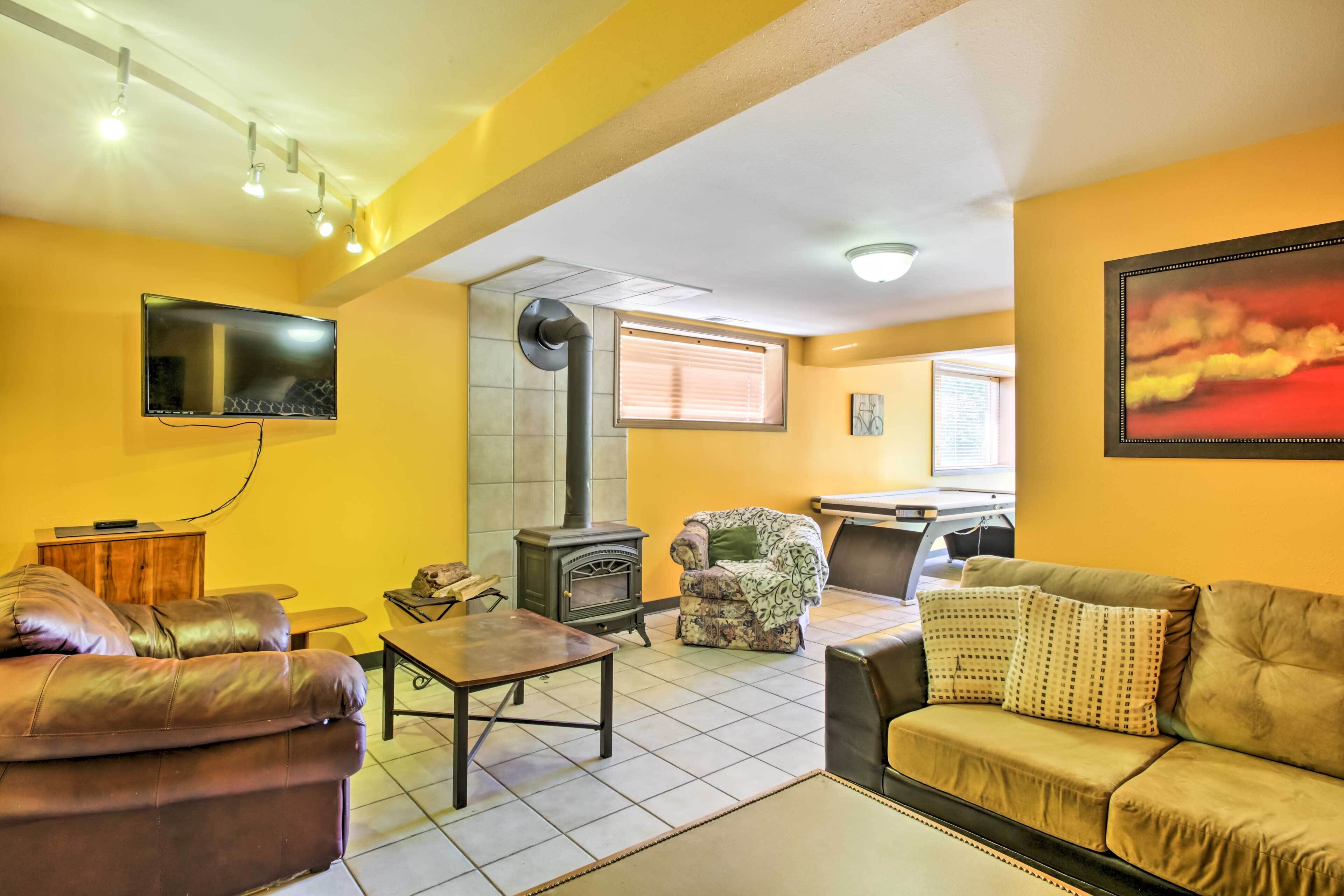 A living room with a fireplace, sofas, a TV, and a dining area.