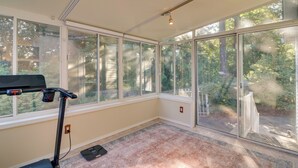 A sunlit room with large windows, a treadmill, and a small rug. - Beautiful Pet-friendly Washougal Home w/ Fire Pit! (Washougal)