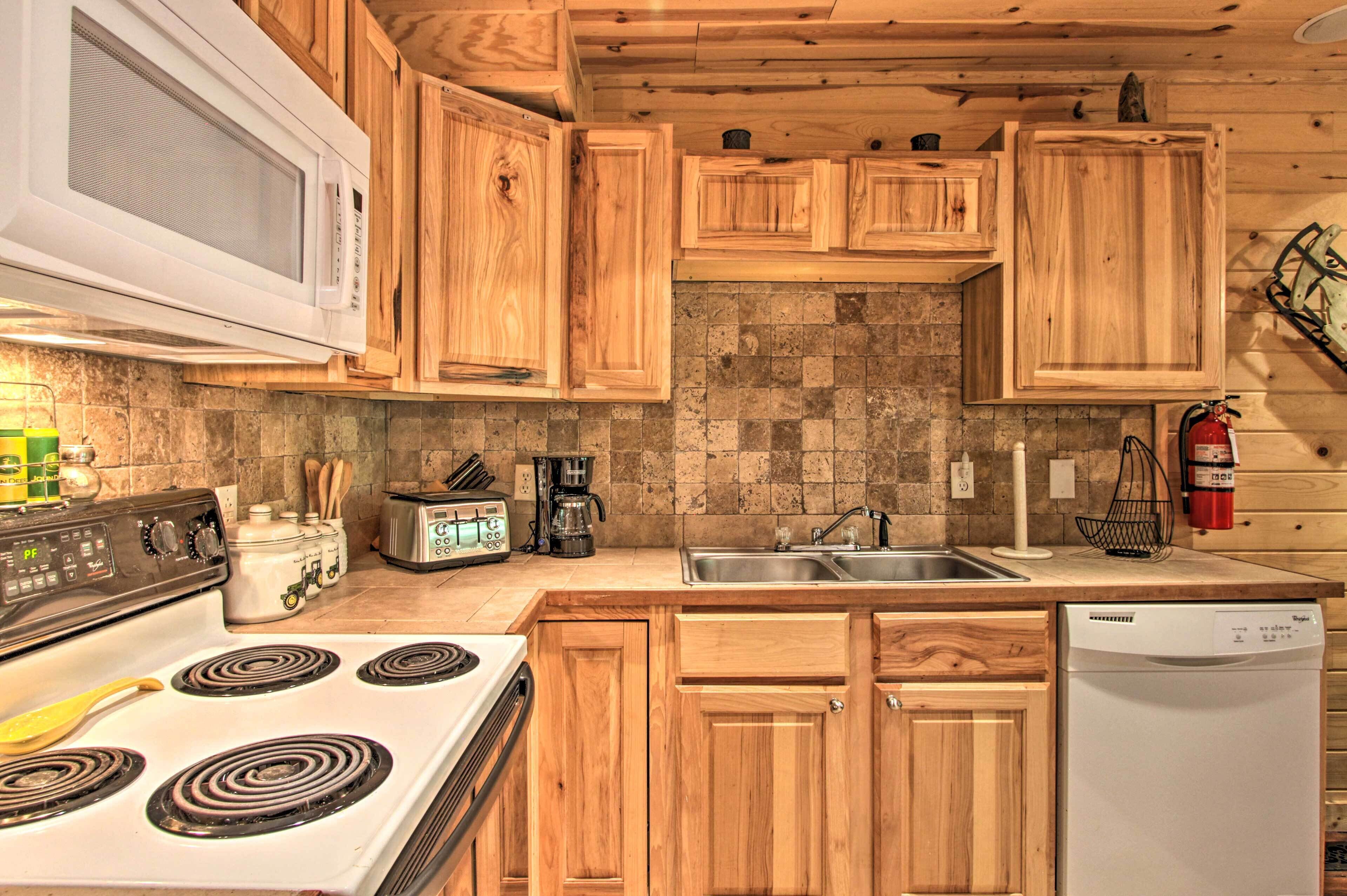 A kitchen with wooden cabinets, a stove, a microwave, a sink, and a dishwasher.