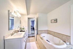 Une salle de bain moderne avec un grand lavabo, une baignoire et un miroir.