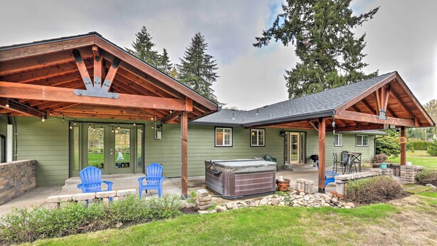 A house with a covered patio, outdoor seating, and a hot tub.